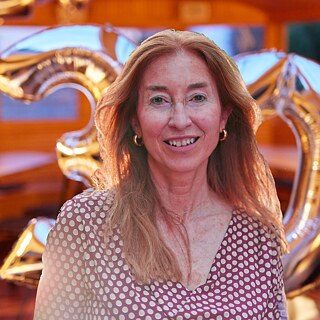 Alumna Cristina Asturias with balloons in the background which result in the number 30 for the anniversary of the Europanetzwerk Deutsch