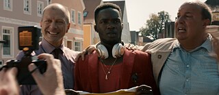 Ein Foto von drei lächelnden Männern wird geschossen.