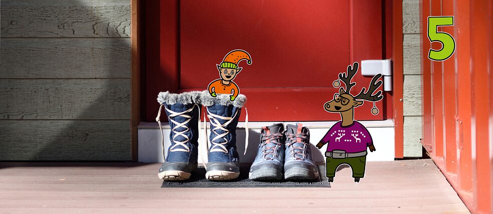 Rentier Matilda und Wichtel Karl stehen lachend vor einer Haustür mit Stiefeln, Karl steckt in einem Stiefel