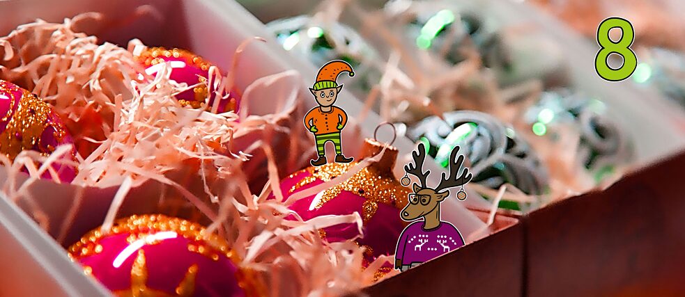 Rentier Matilda und Wichtel Karl stehen in einer Box mit Christbaumkugeln