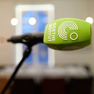 Primer plano de un micrófono con el logotipo del Goethe-Institut.