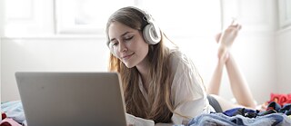 Mädchen mit Laptop und Kopfhörern