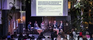 6 people on stage, audience listens