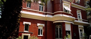 Bücherstapel am rechten Bildrand, der linke Bildbereich zu etwa zwei Drittel unscharf in bläulich-hellen Farben