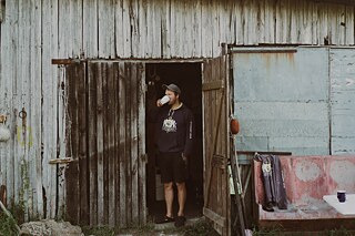 Karolis Tamulis aus Vilnius verliebte sich in seiner Kindheit in die Fischerei, als er die Sommer im Haus seiner Großeltern in Juodkrantė verbrachte. Er genoss es, die Boote, die bunten Fischkisten und die Fischer zu beobachten, die mit ihrem Fang aus der Lagune zurückkehrten. „Morgens um sechs Uhr ist es draußen ganz schön laut, und man hört die Boote (Fischerboote - Anm. d. Red.) hereinkommen. Manchmal konnte man sogar am Geräusch des Motors erkennen, wer ausfuhr. Jeden Sommer habe ich auf meine Rückkehr nach Juodkrantė gewartet“, sagt Karolis. Hier trinkt er gerade einen guten Kaffee neben seinem Fischereilager in der Bernsteinbucht in Juodkrante. 