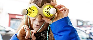 Une femme porte des lunettes sur lesquelles sont collés des volants de badminton.