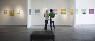 Zwei Besucher einer Galerie betrachten die Kunstwerke. Rückansicht. Kunst, Ausstellung