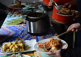 People serving food prepared in a collective cooking session