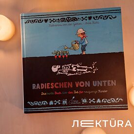 Книжка Radieschen von unten лежить закрита на столі в оточенні свічок