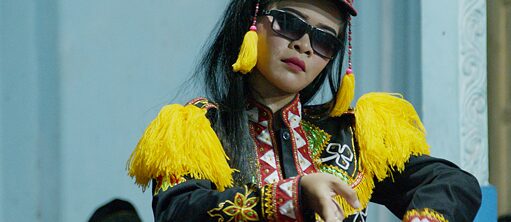 Eine Darstellerin in Sonnenbrille und traditioneller thailändischer Kleidung 