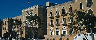 Fassade des imposanten Ledra Palace Hotels in Nikosia. Es ist aus Sandsteine gebaut und hat Bogentüren und kleine Balkons.