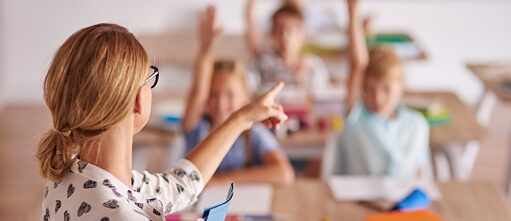 Lehrerin und Schüler*innen im Unterricht