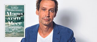 Der Autor Volker Weidermann trägt auf dem Bild einen blauen Anzug. Neben ihm ist das Cover seines letzten Buches "Mann vom Meer" zu sehen, auf dem ein Gemälde mit Wellen abgebildet ist.