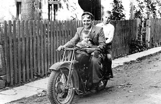 Domininkas Stankus, Schmied, auf einem Motorrad mit seinen Söhnen Algirdas (vorne, etwa 2 Jahre alt) und Leonardas (hinten, etwa 12 Jahre alt). Das Foto wurde um 1950 aufgenommen.