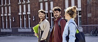 Tres personas están en la calle, yendo a estudiar un curso