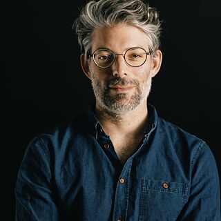 Billedet viser forfatteren Tomer Dotan-Dreyfus på en sort baggrund. 