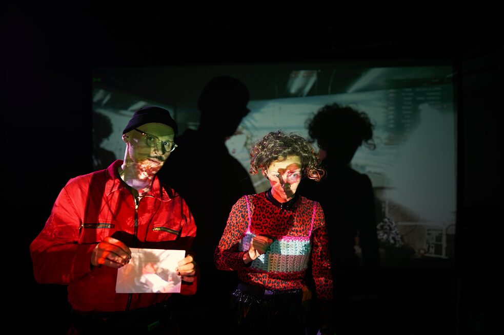 Two people with a beamer projection on their face