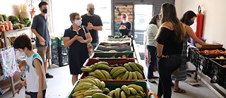 The organic market in the warehouse of Frente Agroecologia Urbana attracts many local residents.
