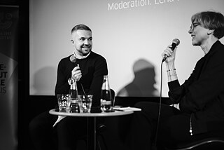 Author Sasha Filipenko in conversation with curator Lena Prents on a stage.