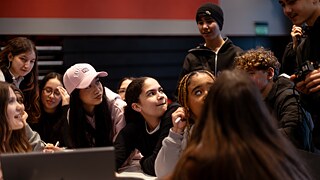 Die Teilnehmenden versammeln sich, um über sich über ihren Arbeitsfortschritt auszutauschen. 