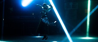 Dancer dances on stage with blue lights