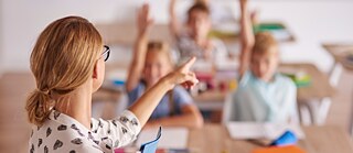 Lehrerin und Schüler*innen im Unterricht