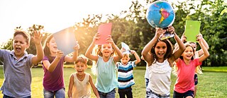 Eine Schülergruppe läuft glücklich durch den Park