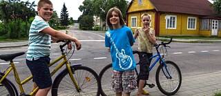 Photo is showing three boys with their bikes in the Lithuanian village of Onuškis. 