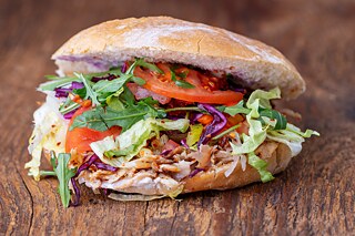 A doner kebab filled with meat and vegetables