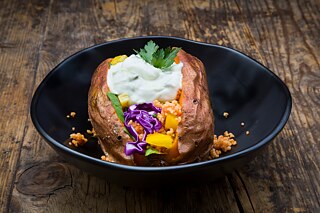 Kumpir filled with all kinds of vegetables, couscous and yogurt