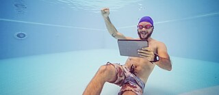 Mann mit Laptop unter Wasser
