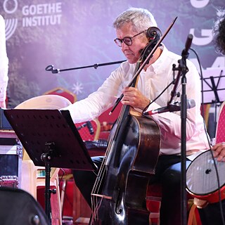 Andreas Vetter reading his notes while holding a cello 
