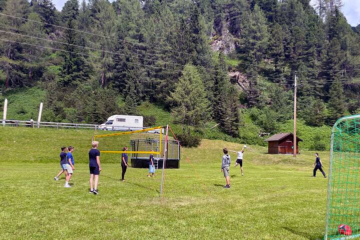 Eine Gruppe Jugendlicher beim Volleyball auf einer Wiese