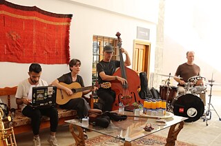 Vier Personen bereiten sich auf Konzerte vor und jammen