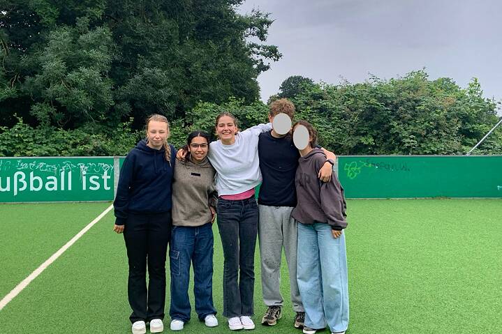 Jugendliche posieren für ein Foto auf einem Fußballplatz