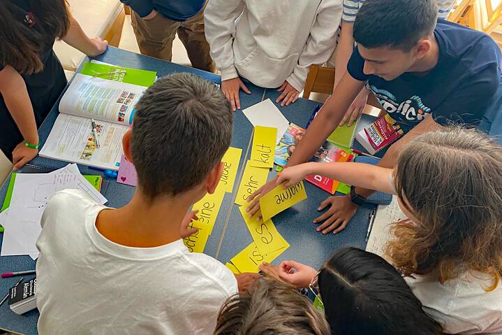 Jugendliche ordnen bunte Karten an einem Tisch
