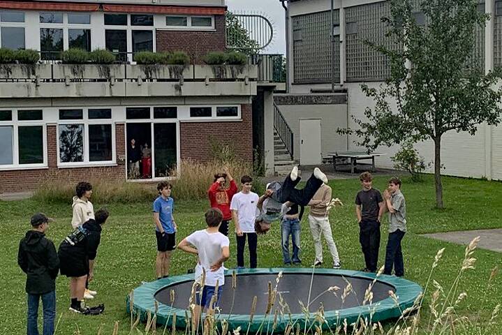 Jugendliche hüpfen auf einem Trampolin und haben Spaß.