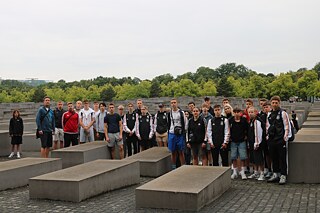 Підлітки стоять біля пам´´´ятника голокосту.