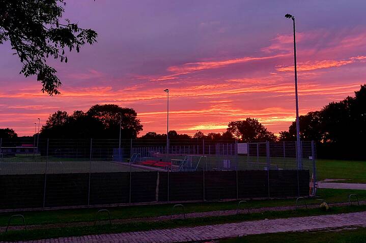 Ein roter Sonnenuntergang über einem Sportplatz