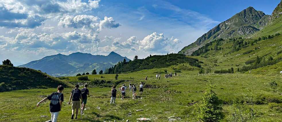 Jugendliche wantern in den Alpen.
