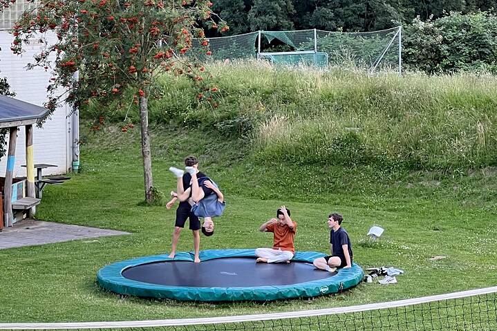 Jugendliche springen akrobatisch auf einem Trampolin.