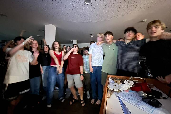 Eine Gruppe Jugendlicher singt und tanzt.