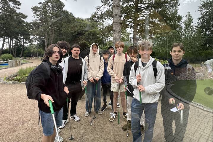 Eine Gruppe Jugendlicher hält Minigolf Schläger in der Hand und posiert für ein Foto.