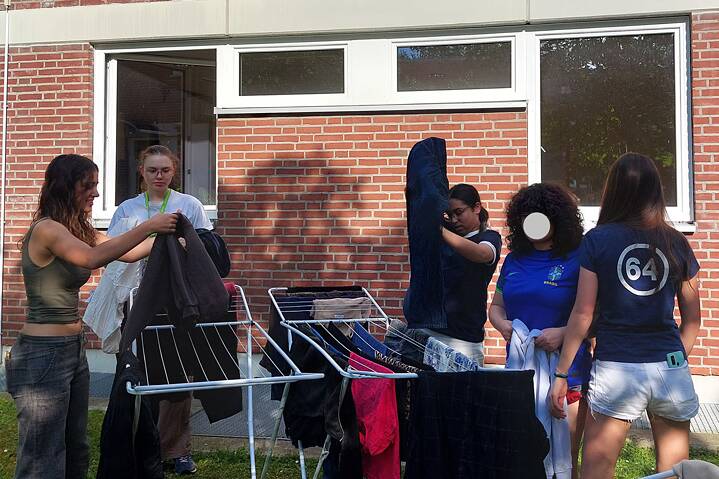 Eine Gruppe junger Frauen hängt Wäsche auf.