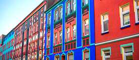 Farbig leuchtende Hausfassaden, bunte Verzierungen und um die Fenster Schnörkel und Dekor: expressionistische Hausfassaden in der Otto-Richter-Straße in Magdeburg.