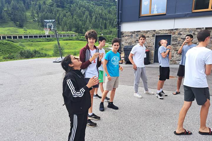 Jugendliche balancieren Gegenstände auf einem Hof.