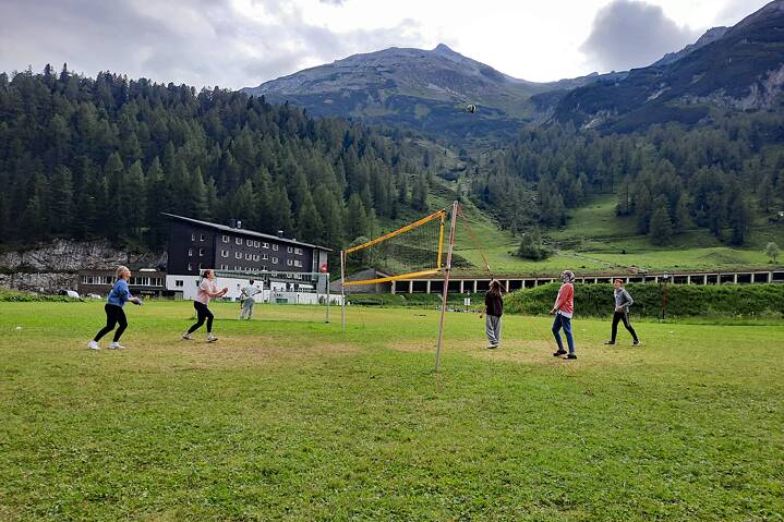 Jugendliche spielen Ball auf einer Wiese.
