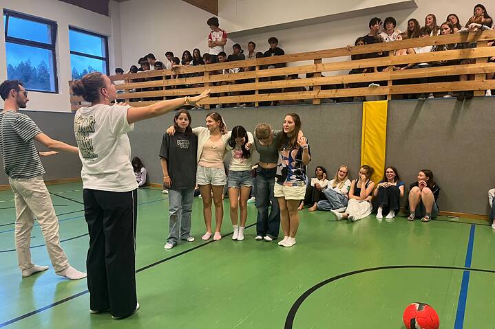 Jugendliche und junge Erwachsene in einer Sporthalle.