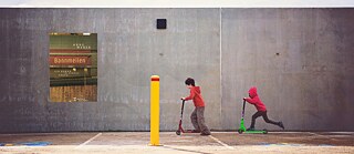Kinder auf Tretrollern vor Mauer (Buchcover: Weber: Bannmeilen)