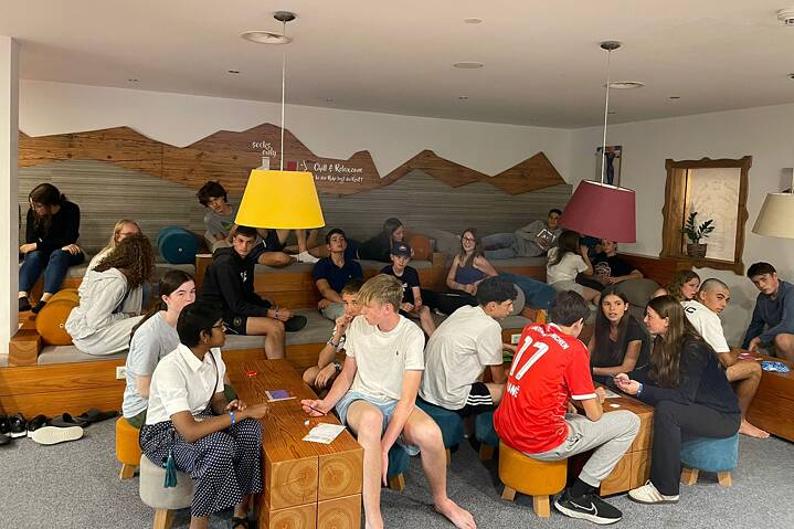 Jugendliche sitzen zusammen und wirken konzentriert.